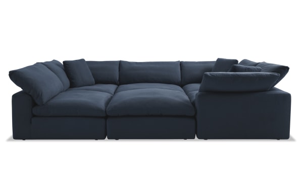 Dream Navy 131'' 6 Piece Modular Sectional in navy blue fabric, transitional style with three corners, two armless chairs, one ottoman, and plush reversible cushions.