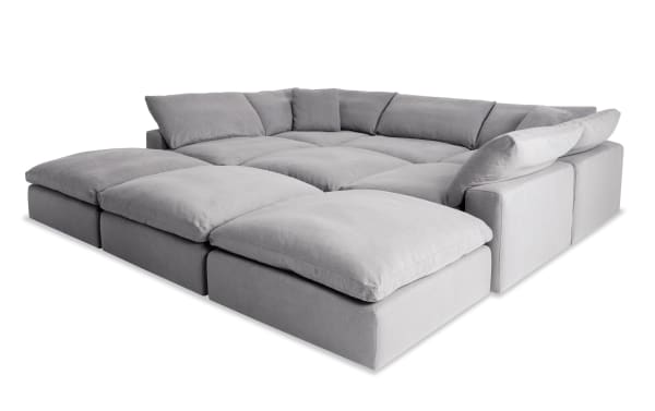Dream Gray 131'' 9-piece modular sectional with 4 ottomans, 3 armless chairs, 2 corners in gray polyester fabric. Transitional style with oversized reversible cushions and feather blend toppers for customizable living room seating.