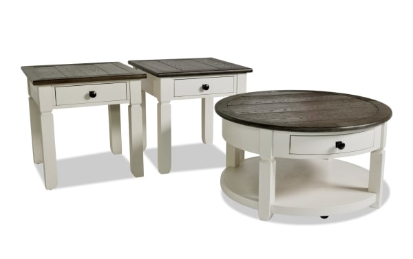 Laurel White & Brown Round Storage Coffee & 2 End Table Set from Laurel Entertainment & Occasional collection. Farmhouse style MDF wood with two-tone white base and dark brown distressed tops. Includes storage drawers with dark hardware, featuring a round coffee table and two square end tables, perfect for living room storage and cottage decor.