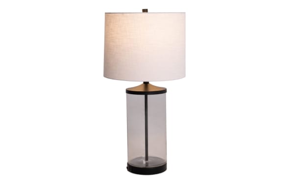 Willow Clear Glass Table Lamp with white fabric shade, clear glass cylindrical base, metal accents, and built-in USB/USB-C charging ports.