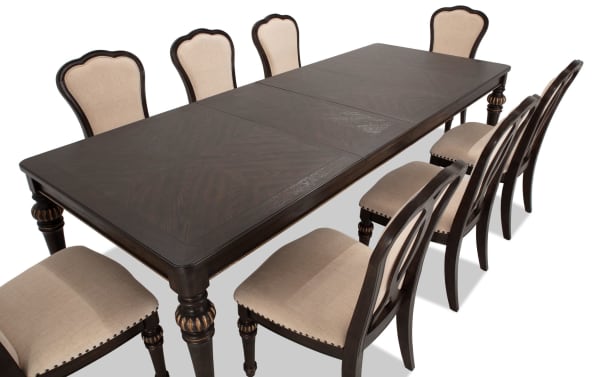 Regency 9 Piece Brown & Beige Upholstered Extendable Dining Set with traditional fluted legs, oak veneer table, and beige polyester fabric chairs with nailhead trim.
