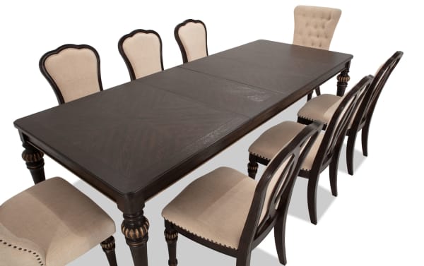Regency 9 Piece Brown & Beige Upholstered Extendable Dining Set with traditional fluted legs, oak veneer table, beige polyester fabric chairs, and nailhead trim.