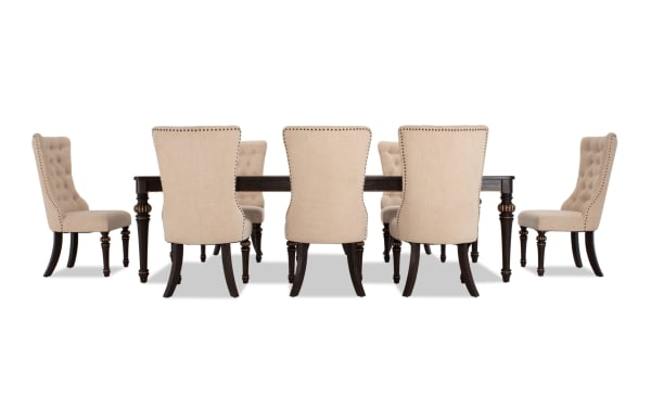 Regency 9 Piece Beige Upholstered Extendable Dining Set with traditional fluted legs, oak veneer table, and cushioned polyester fabric chairs with nailhead trim.