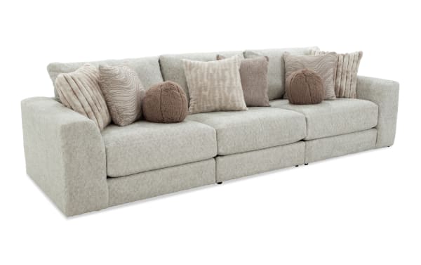 Posh Beige 139" 3-piece modular sofa with plush beige polyester fabric, transitional style, gel-infused memory foam cushions, and nine assorted accent pillows.