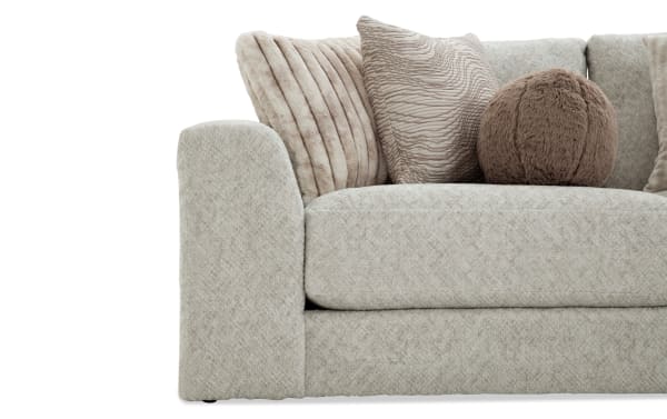 Beige Posh 139'' 3-piece modular sofa with plush polyester fabric upholstery, transitional style, and nine assorted accent pillows including round and textured designs.