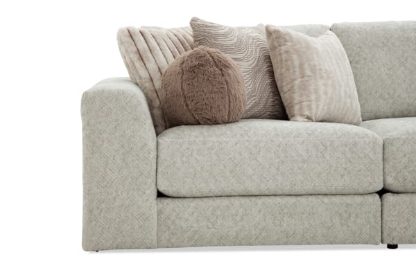 Beige Posh 139'' 4-piece modular sectional with plush polyester fabric, transitional style, and multiple soft accent pillows for living room comfort.