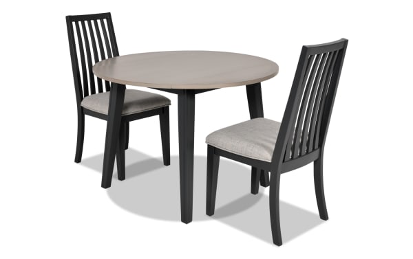 Blake 3 Piece Graphite & Gray Upholstered Dining Set with two gray fabric polyester cushioned slat-back chairs and a round drop leaf table in graphite finish. Compact transitional style dining set made from MDF, hardwood, rubberwood solids, and birch veneers, ideal for small spaces and studio apartments.