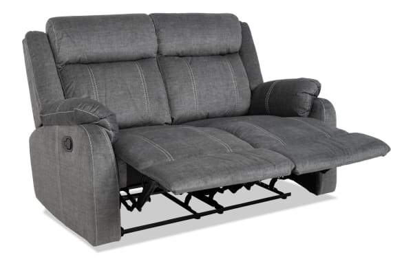 Lagoon Gray 57'' manual reclining loveseat in gray polyester fabric with transitional style, plush cushioning, and padded armrests for adjustable comfort.