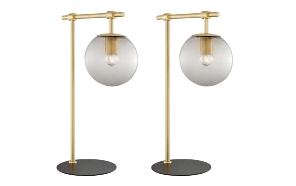 Ezra Gold Table Lamp set of 2 with transitional style, nickel frame, black base, and clear glass globe shade showcasing ambient bulbs for warm lighting.