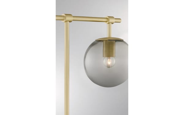 Transitional Ezra Gold Table Lamp with nickel finish, featuring a clear glass globe shade and exposed ambient bulb for warm lighting.
