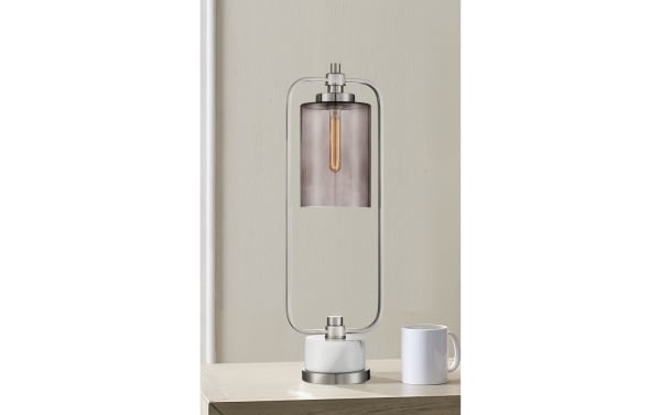 Transitional Liam table lamp with brushed nickel frame, smoky glass shade, and white marble base, featuring an exposed filament bulb and on/off switch.