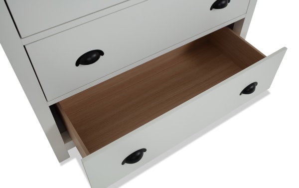 Newport White 5 Drawer Chest from Newport Bedroom collection, transitional style with white MDF and rubberwood, open bottom drawer showing natural wood interior and black cup handles.