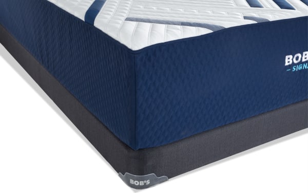 Signature Gel 13.5'' Queen Plush Low Profile Mattress Set from Bob’s Signature collection, featuring a navy blue quilted fabric cover with white and blue top accents and a dark gray foundation base.