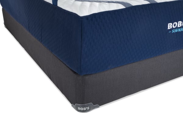 Corner view of Bob-O-Pedic Signature Gel 13.5'' Full Plush mattress set with navy blue quilted cover, white top, and dark gray foundation base.