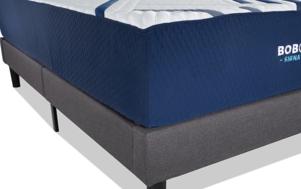 Bob-O-Pedic Signature Gel 13.5" Twin XL Plush mattress set in navy blue with quilted top, shown on gray upholstered foundation with black legs.
