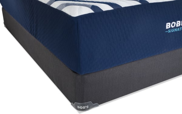 Signature Hybrid 13.5'' Queen Firm Standard Mattress Set from Bob's Signature collection, featuring a navy quilted top with gel memory foam and dark gray fabric foundation.