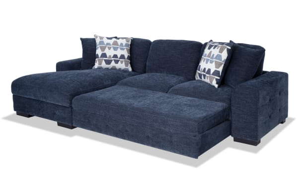 Playground Navy 116" 2 Piece Left Arm Facing Pop-Up Sleeper Chaise Sectional in navy polyester fabric with memory foam cushions, tufted detailing, and oversized accent pillows.