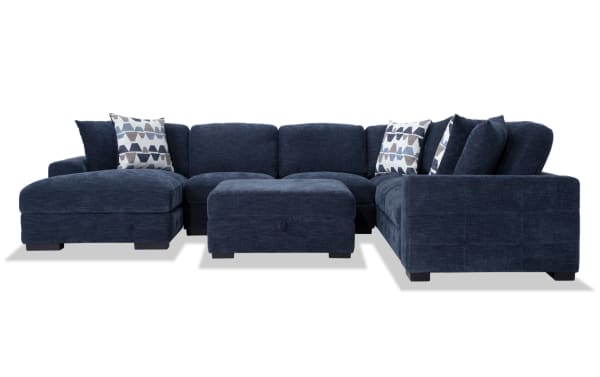 Contemporary Playground Navy 145" 4-piece left arm facing pop-up sleeper chaise sectional with plush polyester fabric, memory foam cushions, hand-tufted detailing, six oversized accent pillows, storage ottoman, and hidden chaise storage.