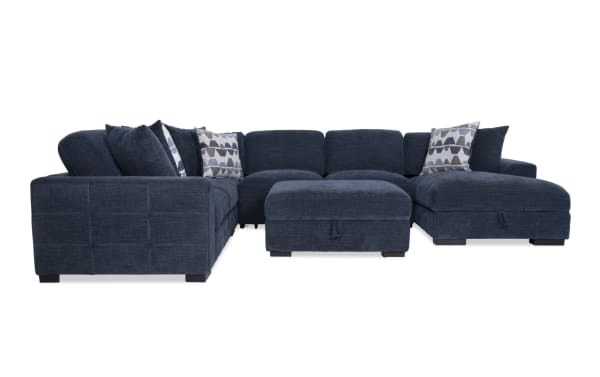 Contemporary Playground Navy 4-piece fabric sectional with right arm chaise, pop-up sleeper, storage ottoman, tufted polyester upholstery, and oversized pillows.