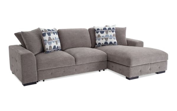 Contemporary Playground Gray 116'' 2 Piece Right Arm Facing Pop-Up Sleeper Chaise Sectional in plush polyester fabric with hand-tufted detailing, oversized accent pillows, and storage ottoman.
