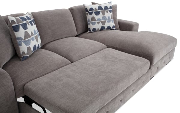 Playground Gray 116'' 2 Piece Right Arm Facing Pop-Up Sleeper Chaise Sectional in gray polyester fabric with memory foam cushions, tufted detailing, and patterned accent pillows.