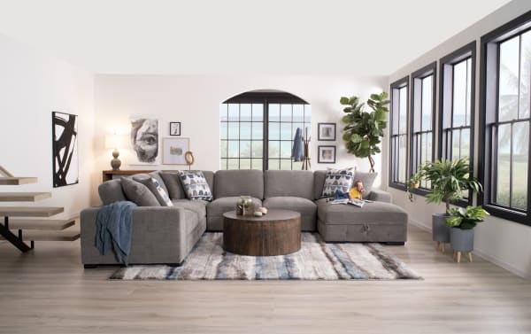 Contemporary Playground Gray 145" 4-piece left arm facing sectional with plush polyester fabric, pop-up sleeper loveseat, storage chaise, and oversized accent pillows.