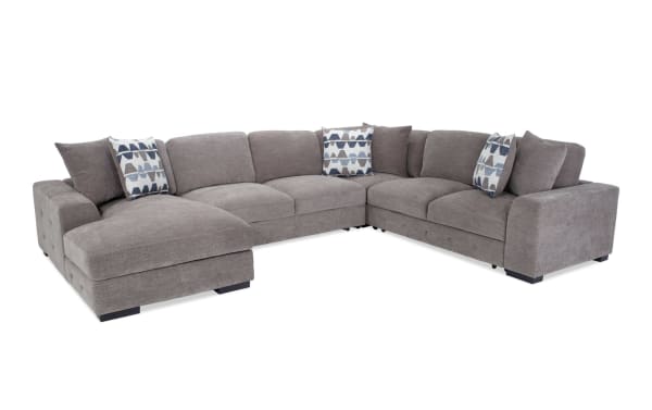 Contemporary Playground Gray 145'' 4-piece left arm facing chaise sectional in gray polyester fabric with deep memory foam cushions, hand-tufted detailing, and oversized accent pillows.
