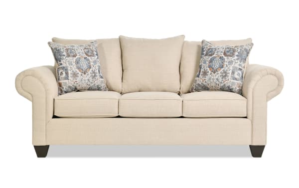 Chloe Beige 88'' transitional sofa from Chloe Living collection, upholstered in beige polyester fabric with rolled arms, three seat cushions, and two patterned accent pillows.