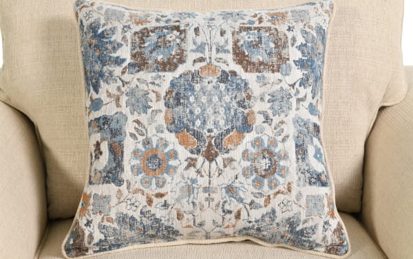 Beige Chloe Living transitional accent chair upholstered in polyester fabric with a decorative blue and brown floral patterned pillow.