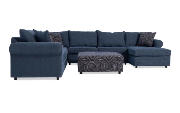 Juno Denim 142" 4-piece right arm facing chaise sectional with ottoman in blue polyester fabric. Transitional style with plush cushions and patterned accent pillows.