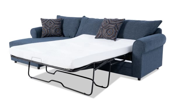 Juno Denim 114'' 2 Piece Left Arm Facing Sleeper Chaise Sectional in blue polyester fabric with transitional style, featuring a full-size pull-out gel memory foam mattress and patterned accent pillows.