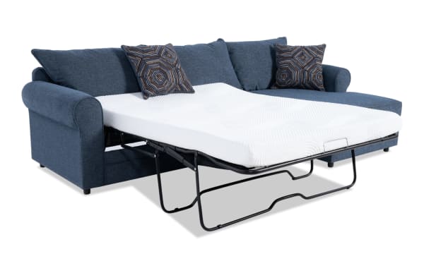 Juno Denim 114" right arm facing sleeper chaise sectional in blue polyester fabric with transitional style, featuring a full-size gel memory foam pull-out mattress and patterned accent pillows.