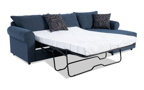 Juno Denim 114" right-arm sleeper chaise sectional in blue polyester fabric with transitional style, featuring a full-size pull-out cooling gel memory foam mattress and patterned accent pillows.