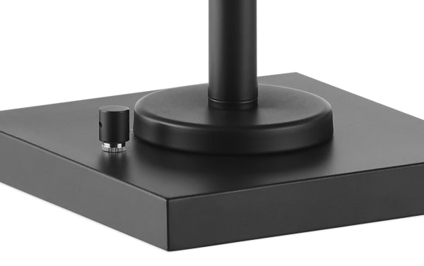Black metal base of Luxe Black Table Lamp set, featuring a round pedestal and a small rotary switch for rustic, industrial style lighting control.