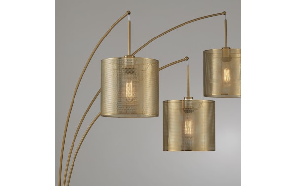 Contemporary Celine Gold Arc Floor Lamp with three curved metal arms and perforated gold metal drum shades, designed to illuminate living spaces.