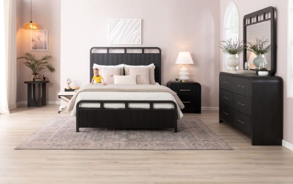 Cascade Twin Black Panel Bed in transitional style with intricate reeding on headboard and footboard, smooth corners, and four symmetrical openings. Made from black MDF and engineered wood grain, part of the Cascade Bedroom collection.