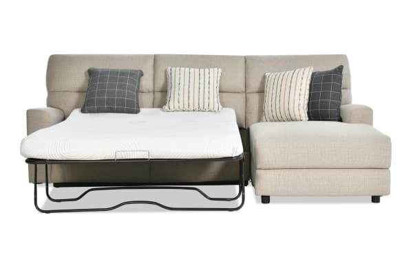 Modern Farmhouse beige 132" right-arm fabric sectional with power reclining sleeper chaise, gel mattress, power headrest, and accent pillows.