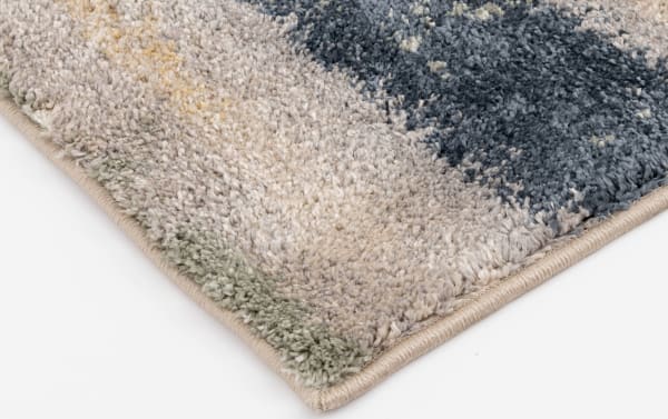 Corner close-up of the Cozy Pastels 8' x 10' Multi Abstract Rug featuring a multicolored abstract pattern in heat set polypropylene fabric with soft pastel and blue tones, ideal for contemporary urban apartment living.
