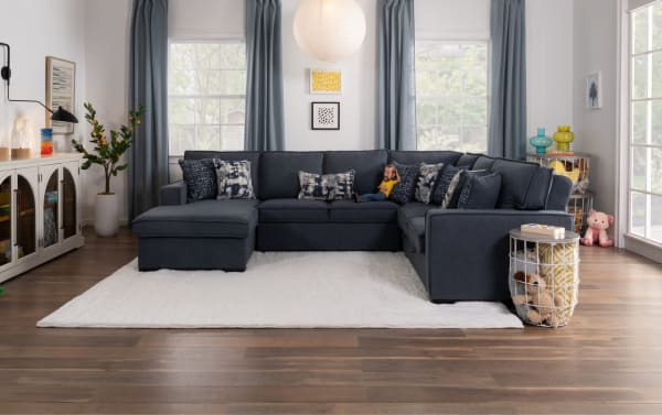 Playmax Denim 99'' 3-piece left arm facing gray sectional sofa with polyester fabric upholstery, Bob-O-Pedic memory foam seating, USB/USB-C ports, pop-up sleeper, and accent pillows in a transitional living room setting.