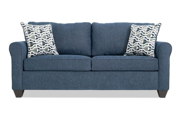 Slumber Navy 80'' transitional sleeper sofa with plush navy polyester fabric, two patterned accent pillows, and a queen gel memory foam mattress.