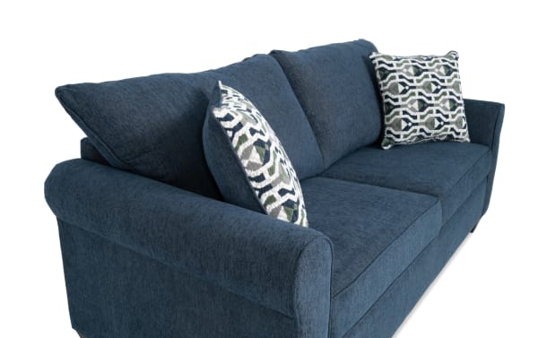 Transitional Slumber Navy 80'' Sleeper Sofa with plush polyester fabric upholstery, two patterned accent pillows, and a queen gel memory foam mattress for comfort.