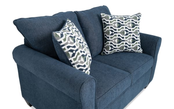 Slumber Navy 56" transitional sleeper sofa in blue polyester fabric with plush cushions and patterned accent pillows, featuring a cooling twin memory foam mattress.