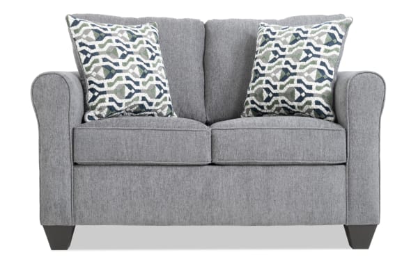 Slumber Gray 56'' transitional sleeper sofa with plush gray polyester fabric, patterned accent pillows, and twin gel memory foam mattress for guest comfort.