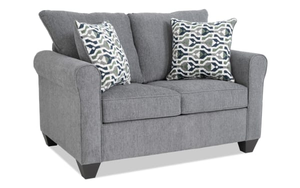 Slumber Gray 56'' transitional sleeper sofa in gray polyester fabric with plush cushions, patterned accent pillows, and a twin gel memory foam mattress.