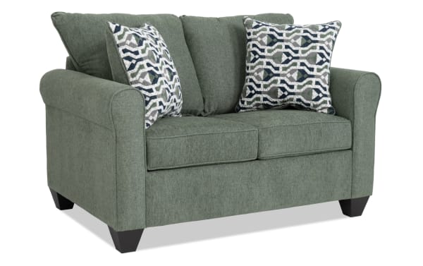 Slumber Green 56'' transitional sleeper sofa in green polyester fabric with plush cushions, patterned accent pillows, and twin cooling gel memory foam mattress.