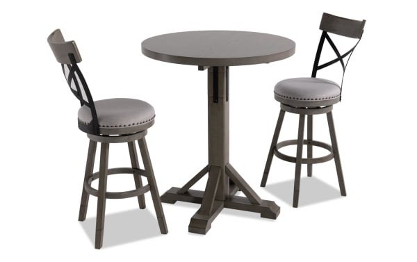 Iris 3 Piece Gray Upholstered Adjustable Height Round Dining Set with swivel stools, nailhead trim, cross-back design, and pedestal table base in transitional style.