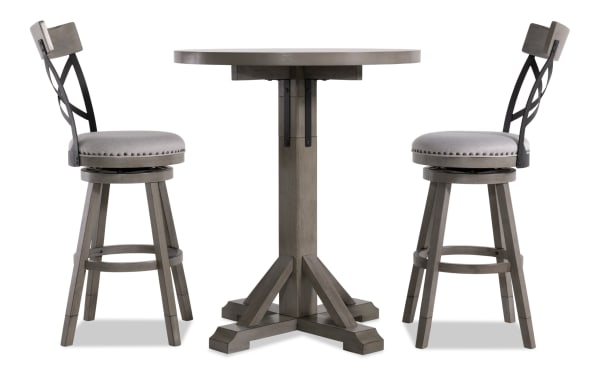 Iris 3 Piece Gray Upholstered Adjustable Height Round Dining Set with swivel stools, nailhead trim, cross-back design, and pedestal table base in transitional style.