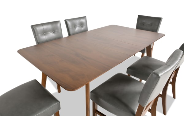Bettie 7 Piece Walnut & Charcoal Faux Leather Upholstered Dining Set with mid-century modern style, flared legs, MDF table, and charcoal faux leather memory foam seats.
