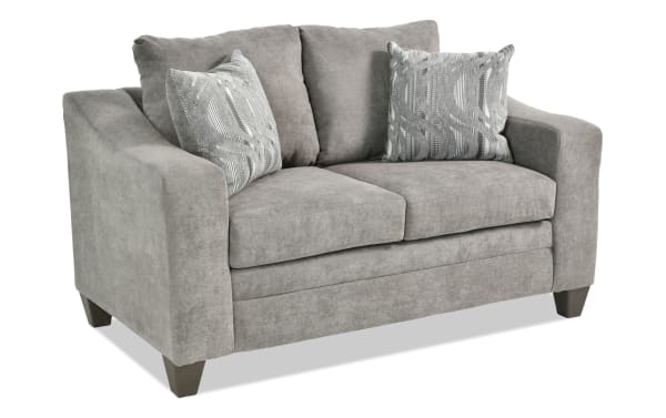 Lucas Charcoal 61'' loveseat with gray polyester fabric upholstery, transitional style, slope arms, tapered legs, and two patterned accent pillows.