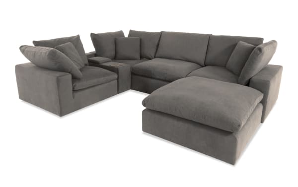 Dream Gray 131" 6-piece modular sectional sofa in gray polyester fabric with USB/USB-C ports, includes 3 corners, armless chair, console, ottoman. Transitional style with oversized reversible cushions and feather blend topper for customizable living room seating.